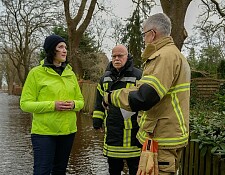Umweltsenatorin Kathrin Moosdorf (links) und Innensenator Ulrich Mäurer (Mitte) lassen sich in Bremen-Borgfeld die aktuelle Hochwasserlage vom stellvertretenden Leiter der Feuerwehr Bremen, Michael Richartz, erläutern. 