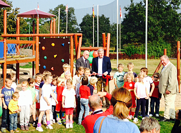 Foto: Walter Messerknecht (Ehrenpräsident BHC), Christian Stubbe (Präsident BHC) und Senator Mäurer mit Kindern auf dem Spielplatz