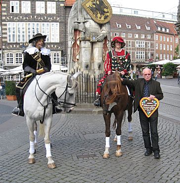 Foto: Senator Mäurer (re) und die beiden auf Pferden sitzenden Abgesandten des Oldenburger Kramermarkts