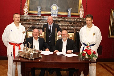 Foto: Andreas Bachmann (li), Senator Ulrich Mäurer, Oliver Henning (re) flankiert von zwei Karatesportlern