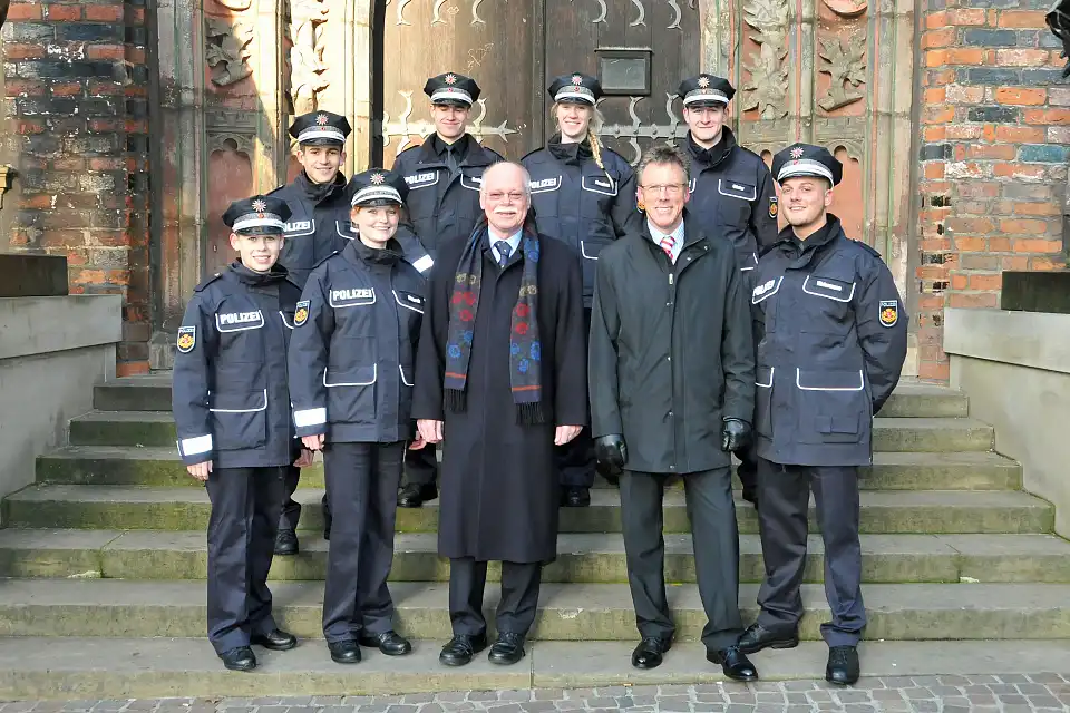 Foto: Senator M&auml;urer (Mitte li), Polizeidirektor Harry G&ouml;tze (Mitte re) mit den Polizeikommissarsanw&auml;rterinnen und &ndash;anw&auml;rtern der Ortspolizeibeh&ouml;rde Bremerhaven