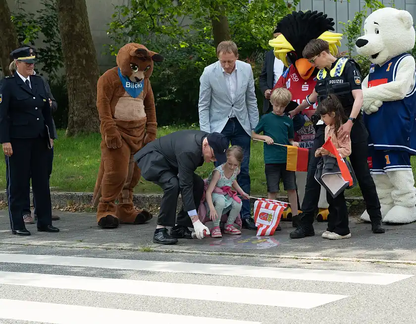 Innensenator Ulrich M&auml;urer malt mit Kindern symbolisch &bdquo;Gelbe F&uuml;&szlig;e&ldquo; auf den B&uuml;rgersteig